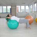 Protažení na gymnastickém míči - procvičování pohyblivosti páteře a protažení svalů na přední straně trupu a svalů nohou